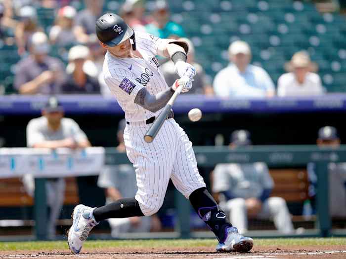 Jul 21, 2021; Denver, Colorado, USA; Colorado Rockies shortstop Trevor Story (27) hits a single in the first inning against the Seattle Mariners at Coors Field.